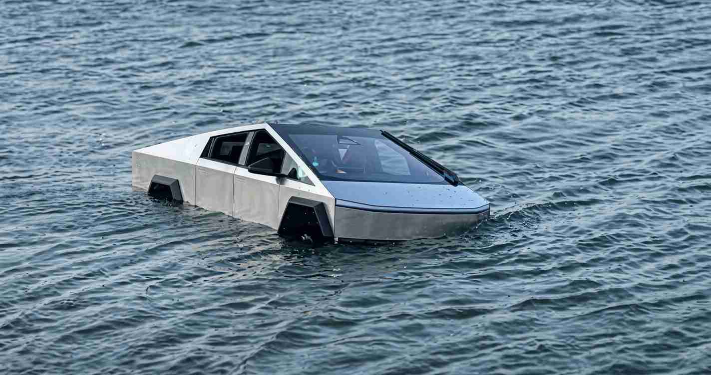 Futuristic silver car with an angular, wedge shape partially submerged in open water.