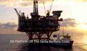Offshore oil platform on stilts with a supply vessel nearby, silhouetted at sunset off the Santa Barbara Coast.