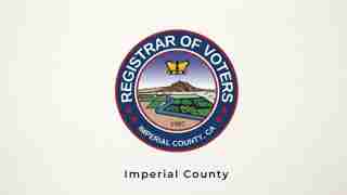 Circular seal of the Imperial County Registrar of Voters featuring a landscape with mountains, river, and fields, crown atop, outer ring text 'Registrar of Voters' and 'Imperial County, CA', 1907 year mark.