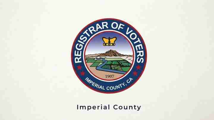 Circular seal of the Imperial County Registrar of Voters featuring a landscape with mountains, river, and fields, crown atop, outer ring text 'Registrar of Voters' and 'Imperial County, CA', 1907 year mark.